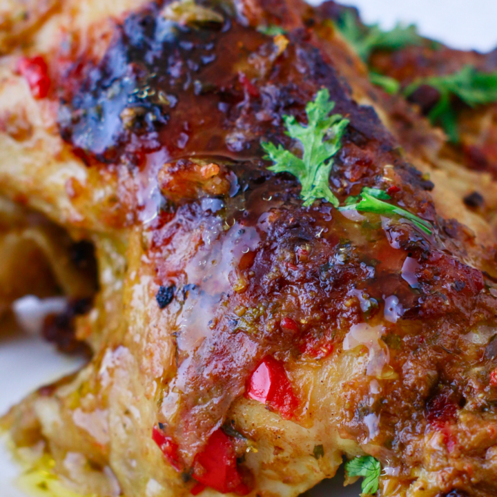 Close-up of juicy Puerto Rican baked chicken (pollo al horno) with crispy skin, marinated in sofrito and spices, perfect for a flavorful Caribbean dinner.