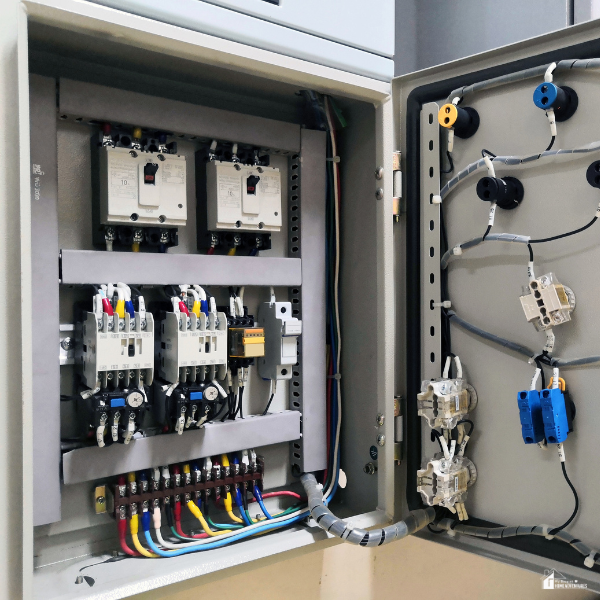 An open electrical switchboard showing multiple safety switches and colored wiring inside.