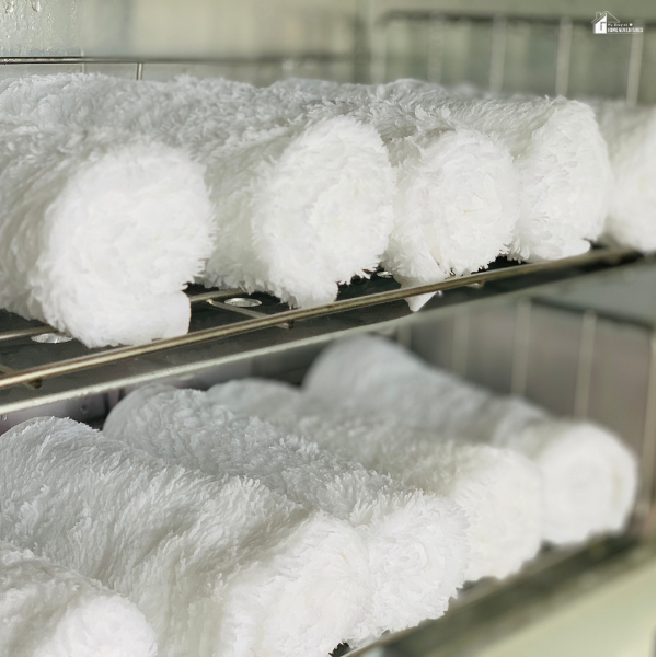 Budget-friendly way to stay cool using rolled cold towels neatly stacked on metal shelves.