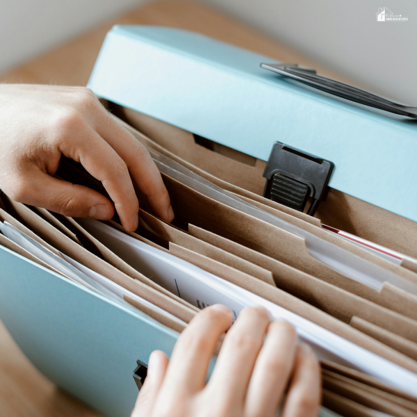 A person organizes important paperwork in a file folder during the moving process.