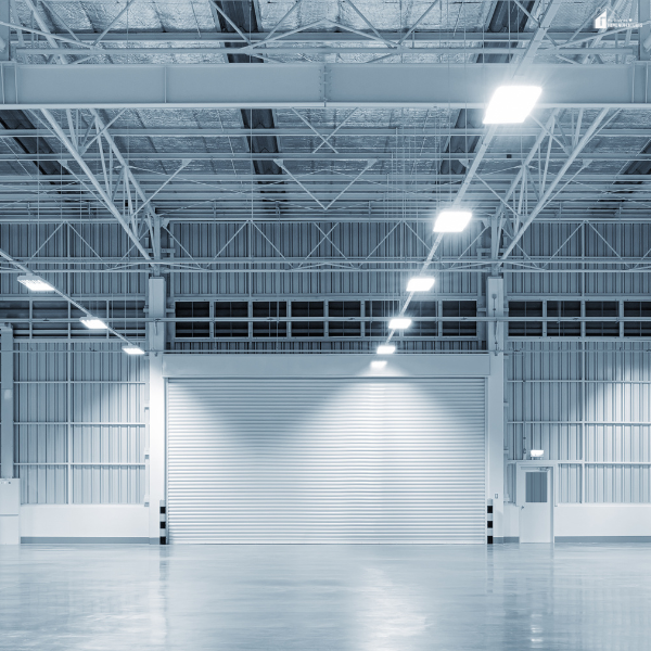 Interior of a large metal building with high ceilings, steel beams, and bright lighting.