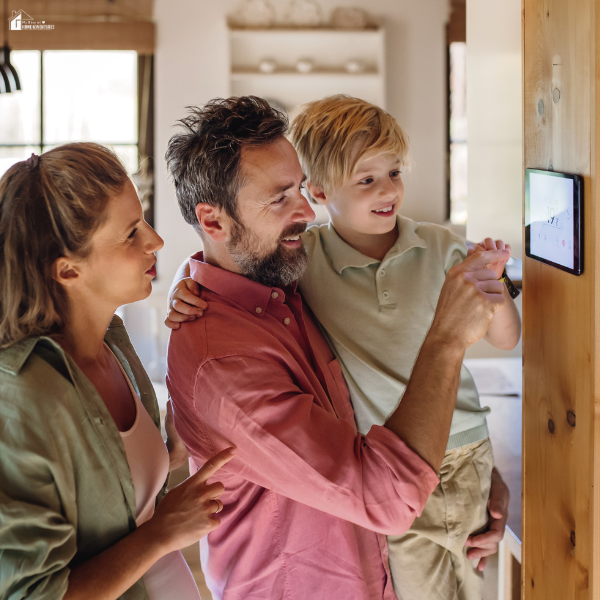 A family adjusts a smart thermostat on the wall to manage home heating and reduce energy costs.