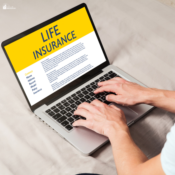 Person typing on a laptop while viewing life insurance information on the screen.