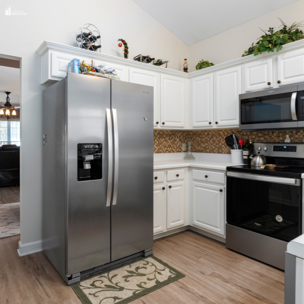 A kitchen with stainless steel appliances and white cabinetry designed for energy-efficient performance.