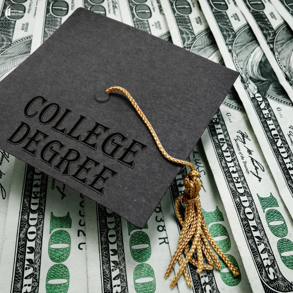 A graduation cap with a tassel placed on a spread of hundred-dollar bills symbolizing education costs.