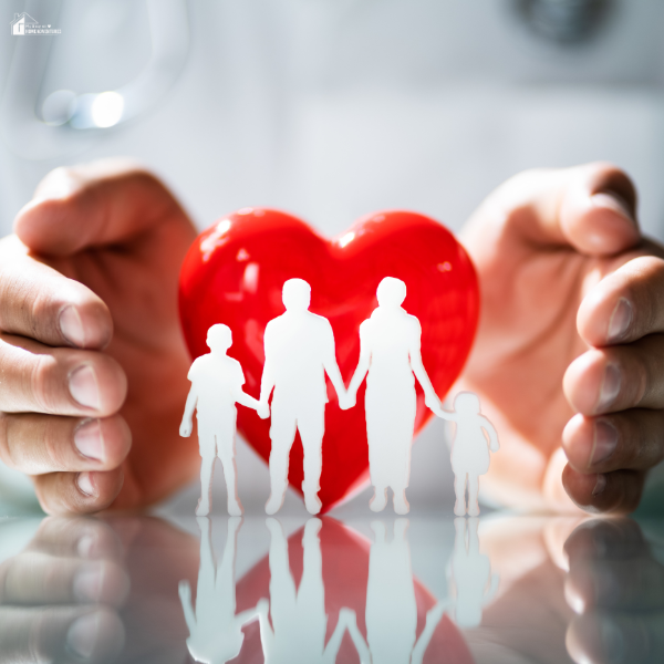 Hands cupping a red heart behind a cutout silhouette of a family of four.