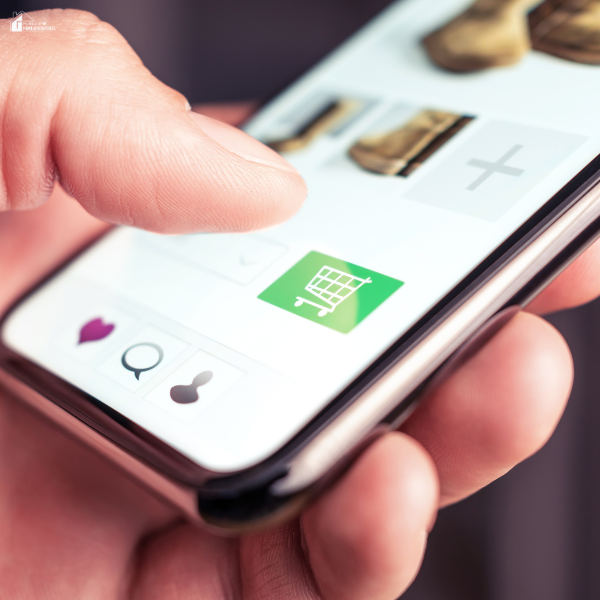 A close-up of a hand tapping the shopping cart icon on a smartphone screen.