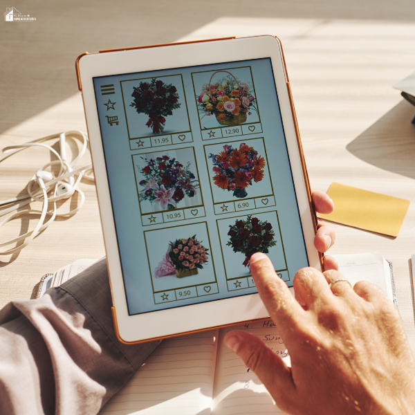 A person browsing flower bouquets and prices on a tablet for online ordering.