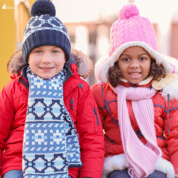 Two children dressed in colorful layers of winter coats, scarves, and knit hats, bundled up for freezing weather.