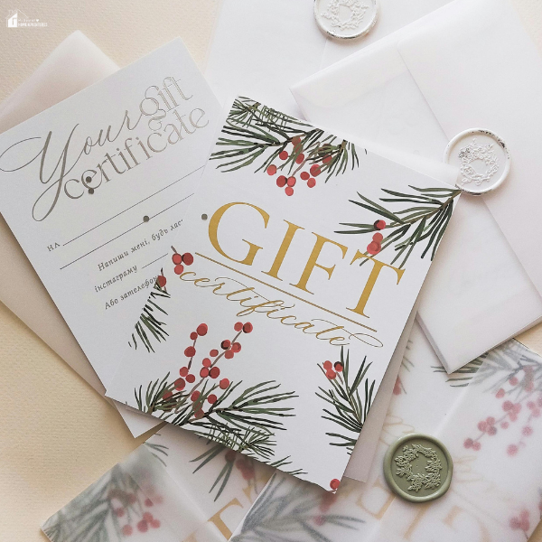 Holiday-themed gift certificates with pine and berry designs placed next to envelopes and wax seals.