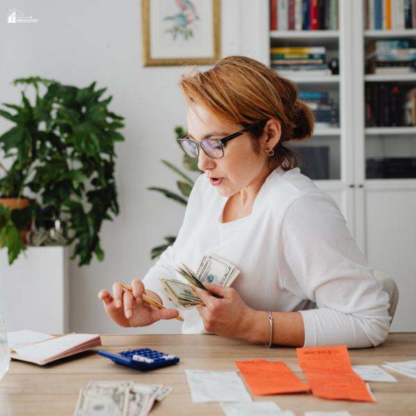 A woman managing her budget at home, counting cash and reviewing receipts as part of a stress-free financial routine.