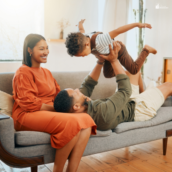 A happy family relaxes together in a bright living room, symbolizing financial security and peace of mind.