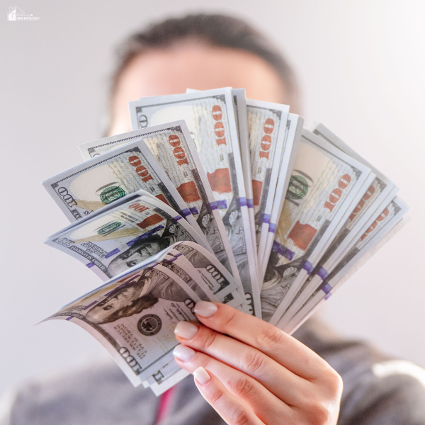 A person holds a fan of hundred-dollar bills, representing smart ways to save money.