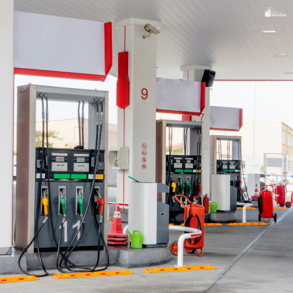 Multiple fuel pumps at a modern, clean gas station with red accents.