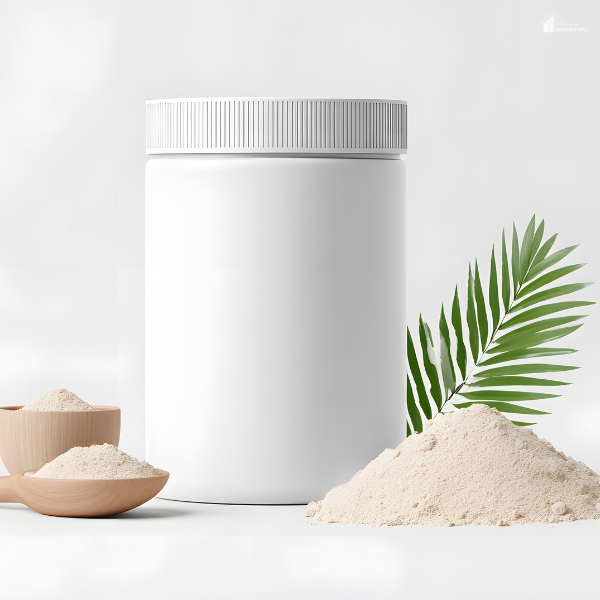 A white container of plant-based protein powder is surrounded by scoops of powder and a green leaf on a white background.