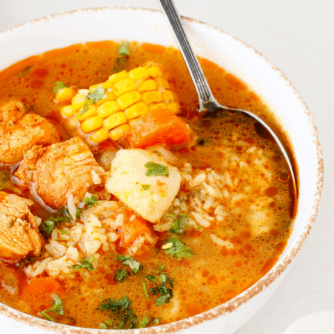 Bowl filled with Puerto Rican chicken soup, showcasing tender chicken, vegetables, and fresh herbs in a rich broth.
