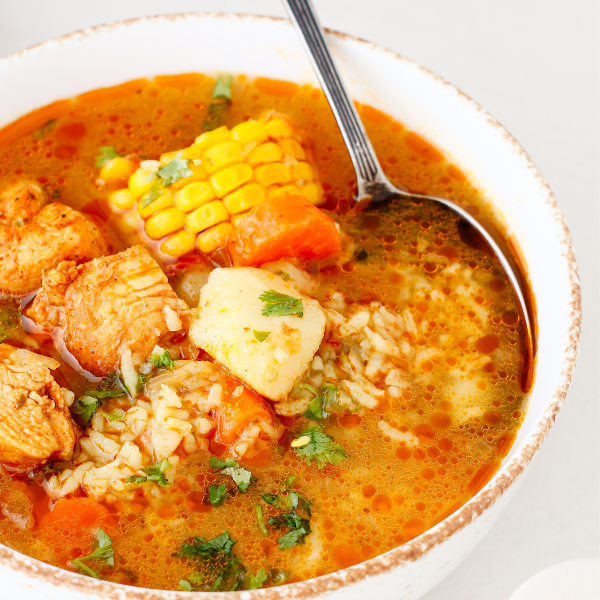 Bowl filled with Puerto Rican chicken soup, showcasing tender chicken, vegetables, and fresh herbs in a rich broth.
