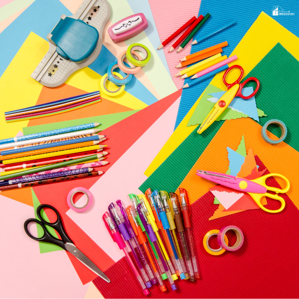 A colorful assortment of DIY crafting supplies including scissors, markers, paper, and tape laid out on a table, ready for storage and labeling.