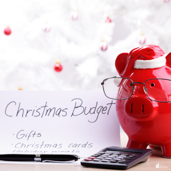 A red piggy bank, calculator, and handwritten Christmas budget list represent managing holiday expenses when prices are rising.