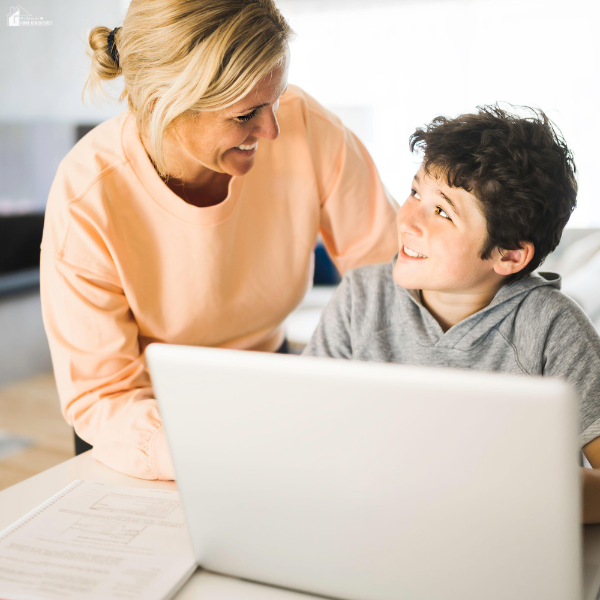 A parent helps a child research career information on a laptop at home.