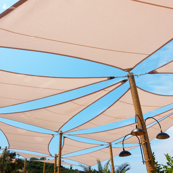 Large overhead shade sails stretched across an outdoor area demonstrate an easy weekend project that transforms a backyard space.