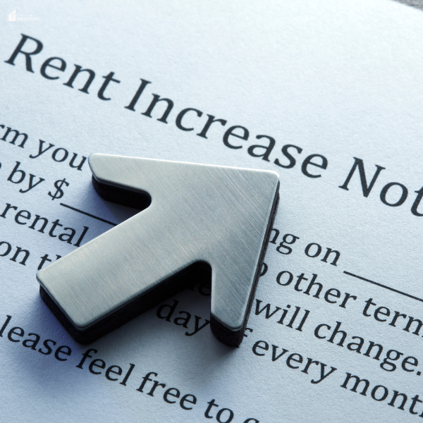 A close-up of a rent increase notice form with a metallic upward arrow placed on top.