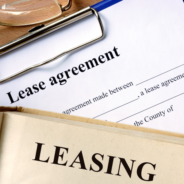 A lease agreement document with a pen and a leasing folder on top of it.