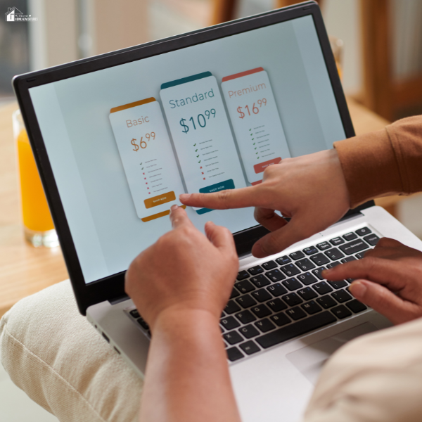 Two people comparing pricing plans on a laptop screen for budgeting options.