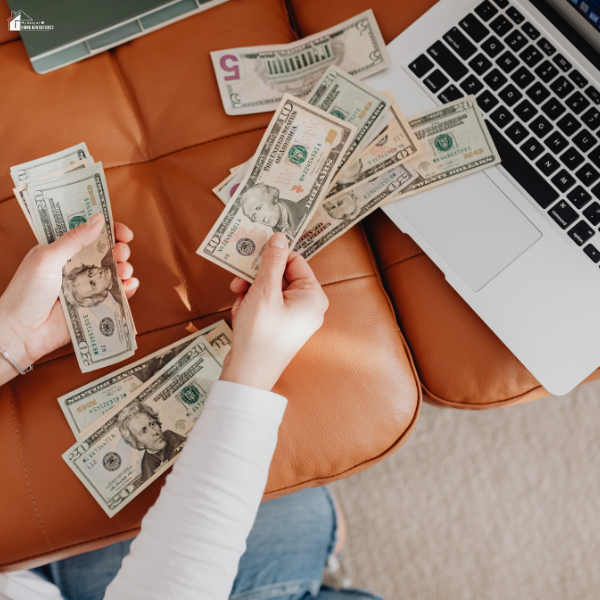Hands counting cash beside a laptop, illustrating how handling tasks digitally can help reduce expenses and improve daily efficiency.
