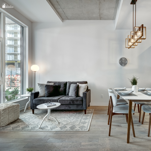 Modern apartment living and dining area with large windows, natural light, and minimal furniture to enhance space.