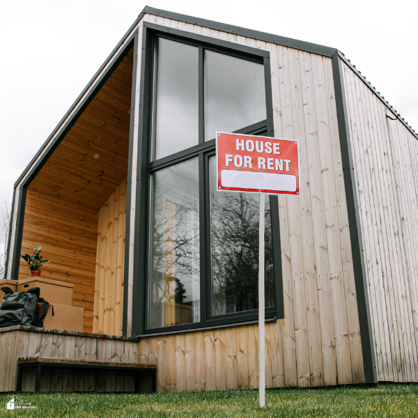 A modern wood-paneled rental home with a red for-rent sign displayed in the front yard, highlighting curb appeal upgrades.