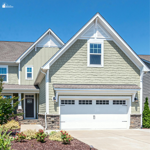A freshly updated home exterior with clean siding, neat landscaping, and a bright garage that reflects simple curb appeal upgrades with fast visual impact.