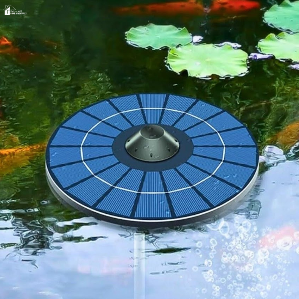 A floating solar-powered aerator releases bubbles in a backyard pond surrounded by fish and lily pads.