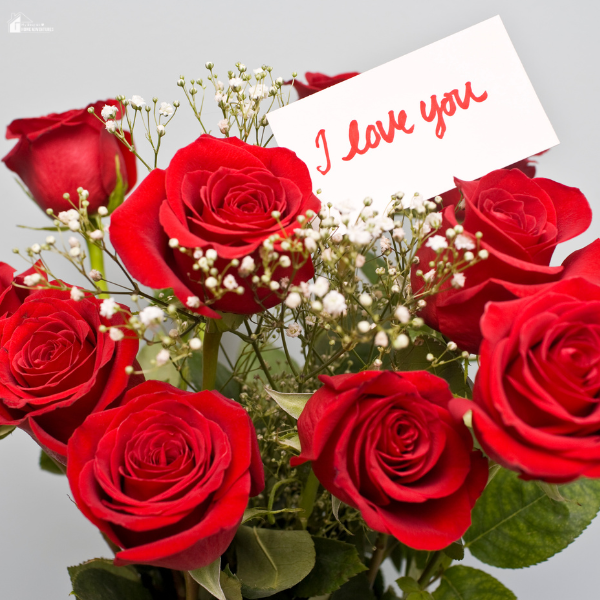A romantic bouquet of red roses with a handwritten love note, showing a classic and stress-free flower choice for Valentine’s Day.