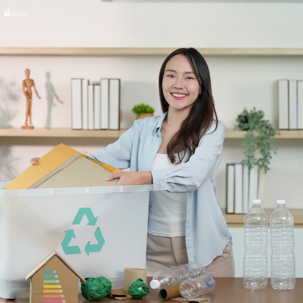 A woman sorts recyclables at home, highlighting the type of clutter handled by garbage removal services.