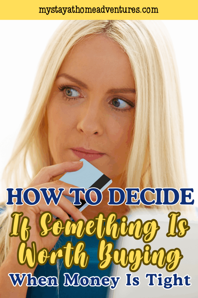 A woman holds a payment card near her face while thinking, symbolizing intentional spending choices when finances require extra care.