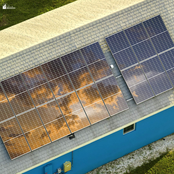 Solar panels on a sloped roof of a colorful home, reflecting the sky, showing solar solutions for large residential properties.