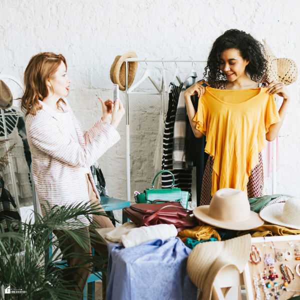 Two women organizing clothing and accessories for resale, showing a practical way to make extra cash without taking on another job.
