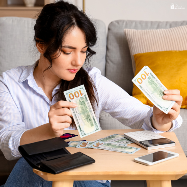 A woman using small tools like a calculator and phone to stretch her family budget more effectively.