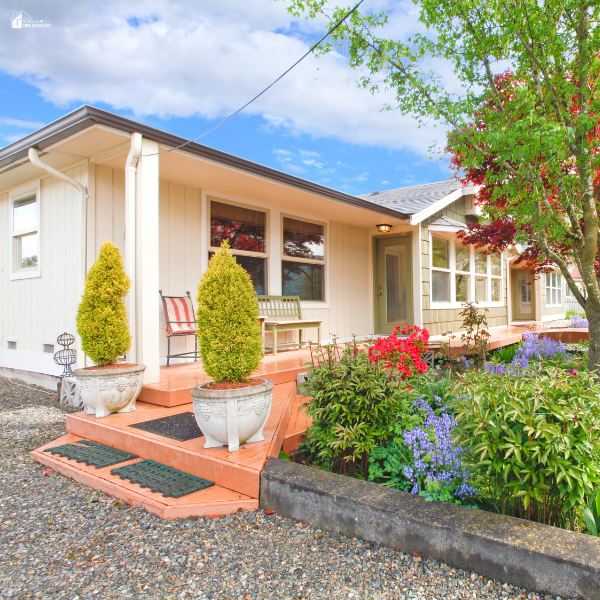 Front porch with fresh paint, potted plants, and colorful flower beds, showcasing budget-friendly upgrades that instantly improve curb appeal.