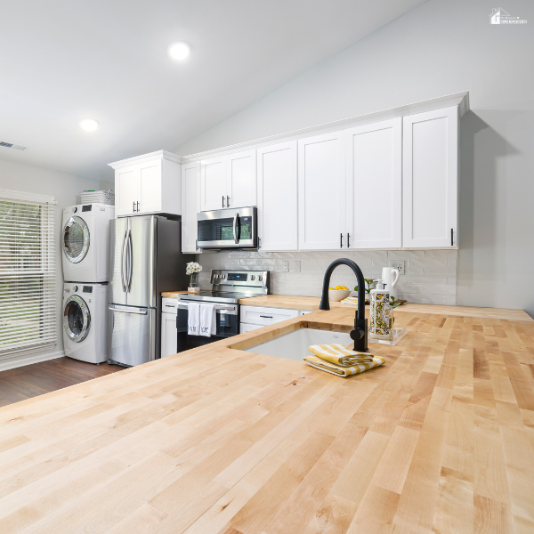 Light-colored butcher block kitchen island in a modern white kitchen, showcasing smooth texture and subtle natural grain detail.
