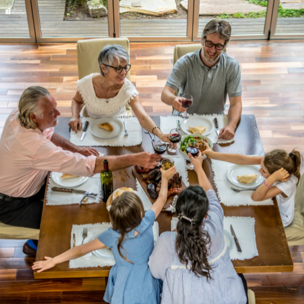 Large family gathered around a dining table sharing a meal, highlighting how restaurant chairs provide sturdy and practical seating for big home dinners.