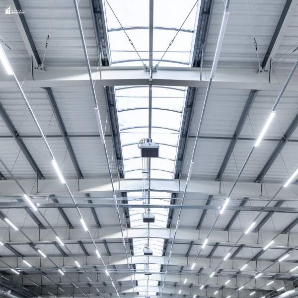 Large commercial warehouse with upgraded LED ceiling fixtures demonstrating energy-efficient lighting improvements that can qualify for higher utility rebate incentives.