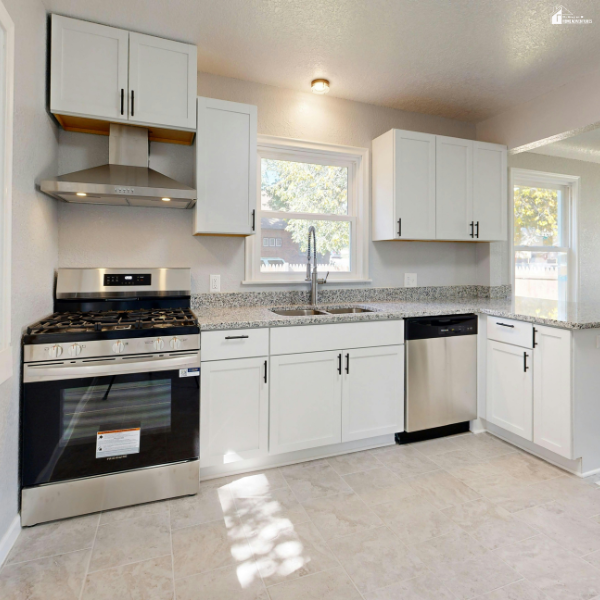 Bright modern kitchen with white cabinetry, granite countertops, and stainless steel appliances designed for practical everyday cooking.