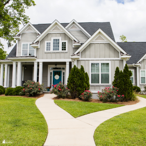 Suburban home with fresh landscaping, clean walkway, and neatly trimmed shrubs showing affordable ways to enhance curb appeal on a budget.