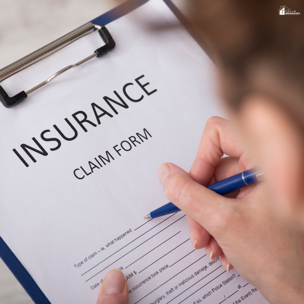 A person filling out a claim document on a clipboard, representing the process of seeking compensation through coordinated insurance coverage.