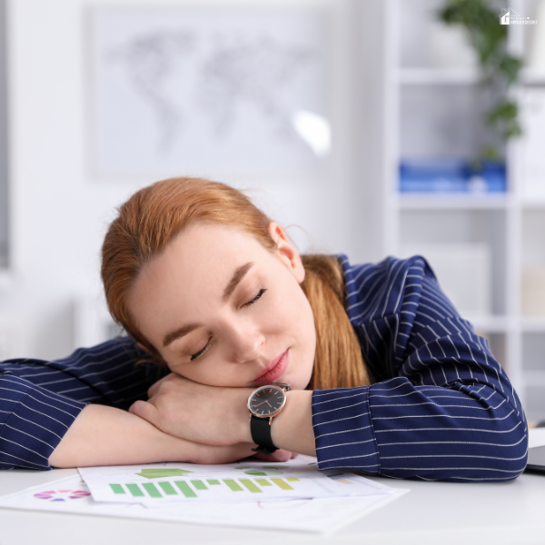 Exhausted professional resting at a desk with paperwork, illustrating burnout caused by an unbalanced weekly schedule.