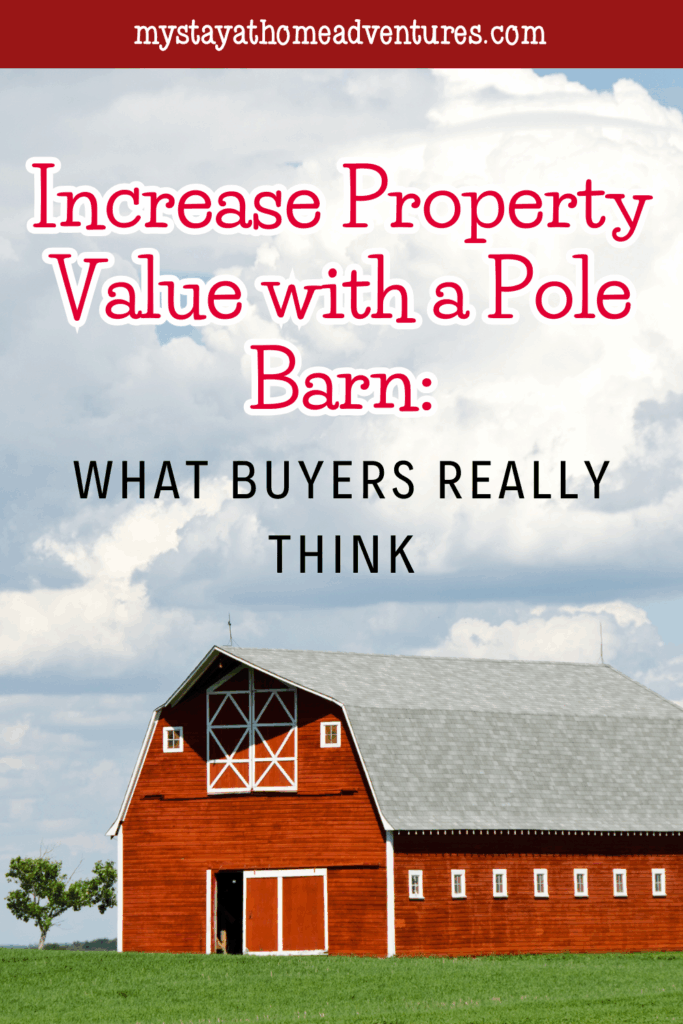 A large red barn with a gray gambrel roof stands in an open grassy field with a cloudy sky in the background.