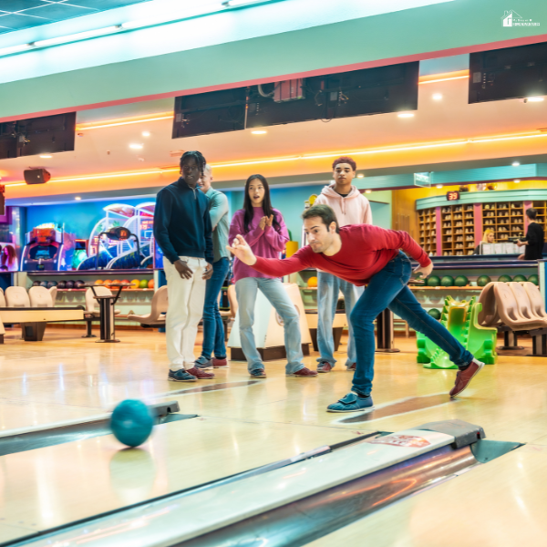 Friends bowling together during league season, representing stylish team apparel and personalized shirts for end-of-winter matches.