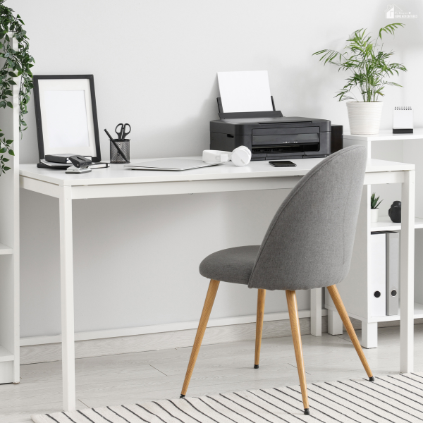 A minimalist home office setup featuring a white desk with slim legs and a modern gray chair, emphasizing clean lines and functionality.